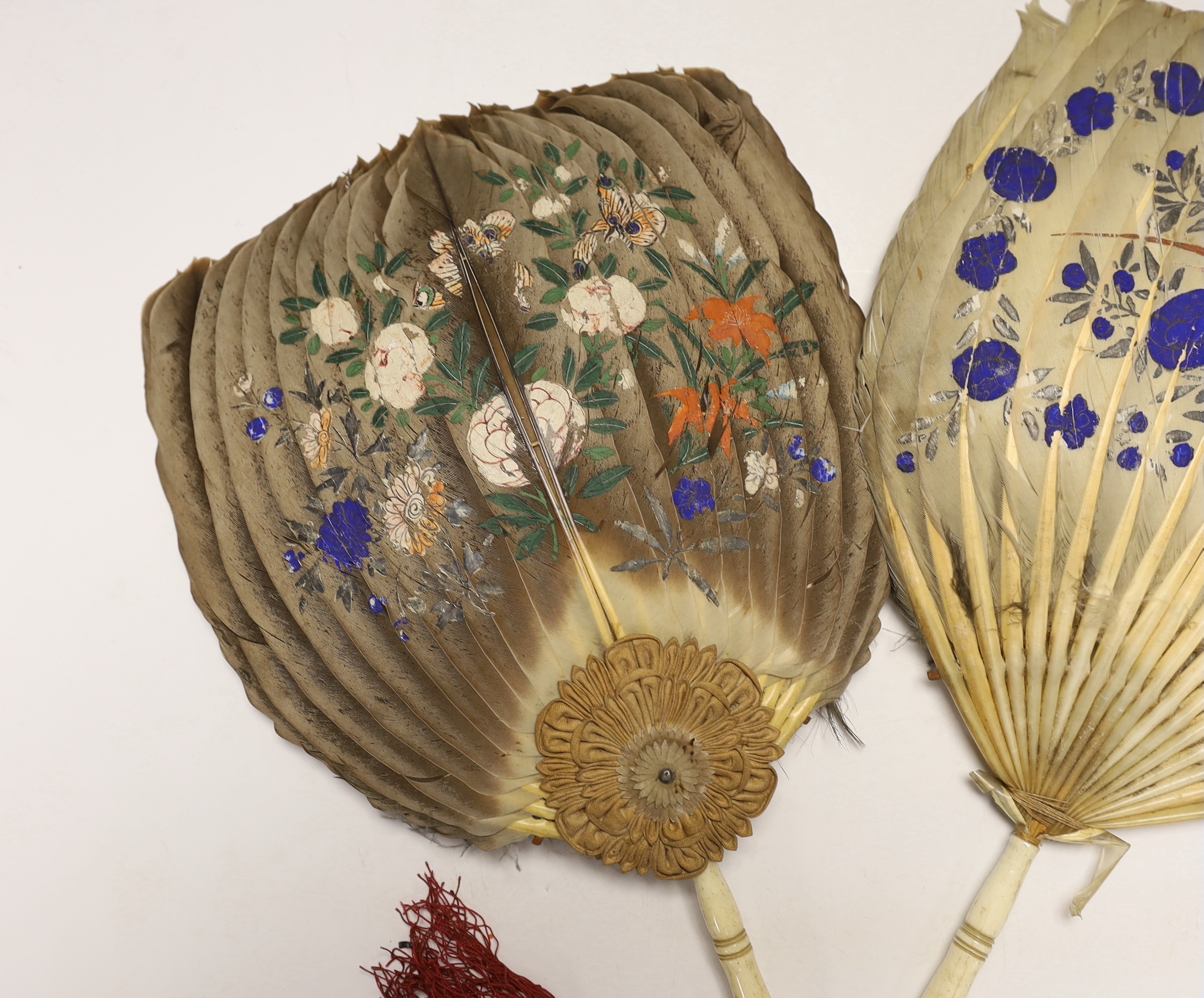 Two feather and bone handled Regency feather fans, the feathers hand painted with Chinese figures one side and flowers the other, one fan has silk rosettes with mother of pearl and feather ornamentation to the top of the